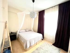 ein Schlafzimmer mit einem weißen Bett mit einem hängenden Baldachin in der Unterkunft Cozy House in Izmir