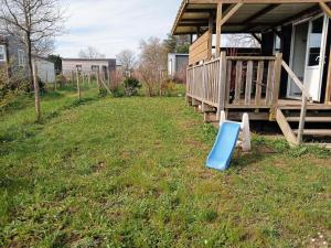 a yard with a blue object in the grass at LE RHUYS, mobil home cosy proche des plages in Sarzeau +7 photos