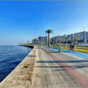 a pier with a person riding a bike next to the water at Cozy House in İzmir