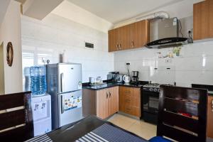 a kitchen with white appliances and wooden cabinets at Lalucia in Nairobi