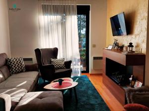 - un salon avec un canapé et une cheminée dans l'établissement Apartman Luka Casa, à Zlatibor