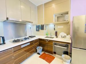 a kitchen with wooden cabinets and a stainless steel refrigerator at R&F Princess Cove Johor Bahru By SShineHome in Johor Bahru