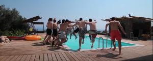 a group of men standing around a swimming pool at Villa Freebird - Exclusive VIP Wedding & Bachelor Events in Pefkohori