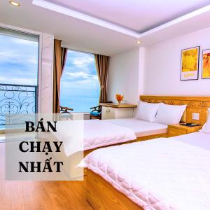 Habitación de hotel con 2 camas y ventana en Nắng Vàng Nha Trang Hotel, en Nha Trang