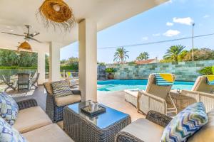 a patio with wicker furniture and a swimming pool at Villa Paradise in El Campello