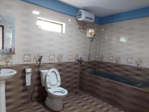 a bathroom with a toilet and a bath tub at Restful River Villas in Phong Nha