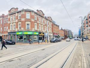 an empty city street with buildings and cars on the road at The Idyllic City Centre Apartment & Free Parking in Sheffield