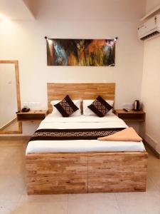 ein Schlafzimmer mit einem großen Holzbett in einem Zimmer in der Unterkunft RAINBOW ROOMS in Kozhikode