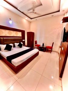 Hotel Wood Lark Zirakpur Chandigarh- A unit of Sidham Group of Hotels في شانديغار: غرفة نوم بسرير وطاولة وكراسي