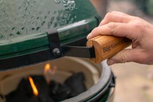 a person holding a wooden object in front of a fire at Hotel Restaurant Rössli in Schönenberg