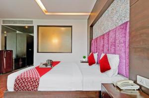 een slaapkamer met een wit bed met rode kussens bij hotel ryan in New Delhi