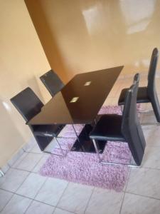 stół z 2 krzesłami i laptopa w obiekcie Costal Road hideout! w mieście Ghana Town