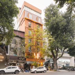 ハノイにあるM Village Hotel Hồ Gươmの横にネオンサインが付いた建物