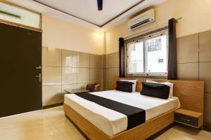 a bedroom with a large bed and a window at Hotel O 7 in Lucknow