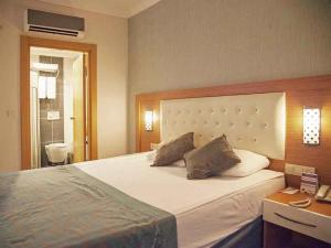 a bedroom with a large white bed with two pillows at Side Win Hotel & Spa - All Inclusive in Side