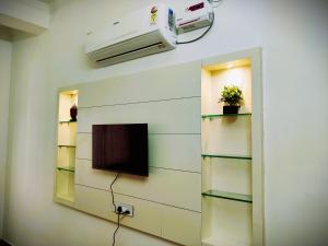 a room with a wall with shelves and a tv at Hotel Neelkanth Prime Retreat, Kekri in Kekri