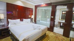 a bedroom with a large bed and a bathroom at SkyCity Hotel Gurgaon in Gurgaon