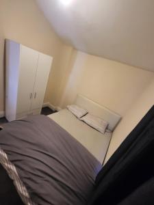 a small room with a bed and a cabinet at UNIVERSITY HOMES in Middlesbrough