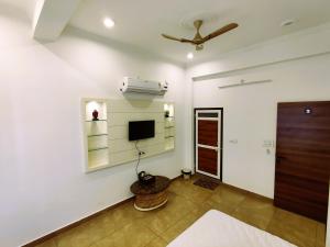 a living room with a television and a ceiling fan at Hotel Neelkanth Prime Retreat, Kekri in Kekri