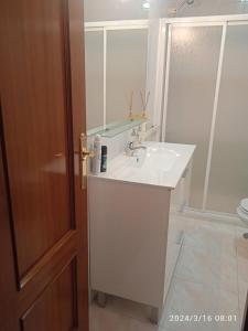 La salle de bains est pourvue d'un lavabo blanc et d'un miroir. dans l'établissement Casa Paco, à Luque