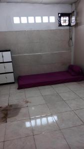 Habitación con cama morada en el suelo de una habitación en Rumah Kost 10 Gambir en Yakarta