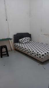 Rumah Kost 10 Gambir في جاكرتا: غرفة بيضاء مع سرير وطاولة