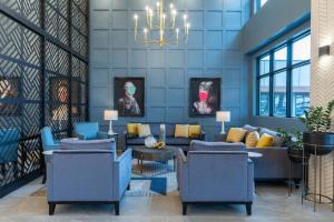 a lobby with a couch and chairs and a chandelier at Sandman Signature Dartmouth Hotel & Suites in Halifax