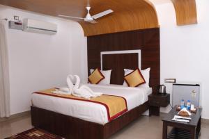 a bedroom with a large bed with a wooden headboard at CS Arunachala Residency in Tiruvannāmalai