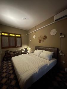 1 dormitorio con 1 cama grande con sábanas y almohadas blancas en The Grand Bali Hotel en Melaka