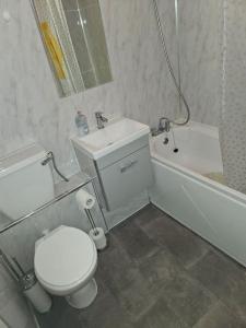 a bathroom with a toilet and a sink and a tub at tranquility in Enfield