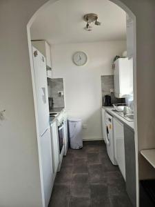 a small kitchen with white appliances and a hallway at tranquility in Enfield