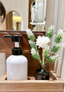 a soap dispenser and flowers in a wooden box at Apec Mandala HaDoFinn in Tuy Hoa