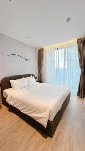 a large bed in a bedroom with a large window at Apec Mandala HaDoFinn in Tuy Hoa