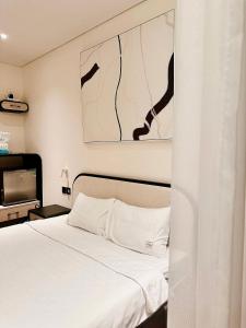 um quarto com uma cama branca e uma televisão em Apec Mandala HaDoFinn em Tuy Hoa