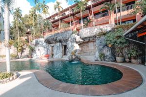 a swimming pool in a resort with a waterfall at C & N Resort and Spa - SHA Extra Plus in Patong Beach