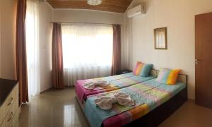 a bedroom with a bed with towels on it at Sani Holiday Village in Sozopol +114 photos