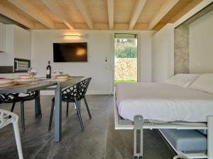 een slaapkamer met een bed en een tafel met stoelen bij Villa Sunny Lake Suites in Bardolino