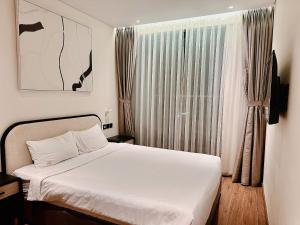 1 dormitorio con cama blanca y ventana en Apec Mandala HaDoFinn en Tuy Hoa