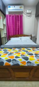 ein Schlafzimmer mit einem Bett mit einer bunten Bettdecke in der Unterkunft ANDAMAN EXQUISITE in Port Blair