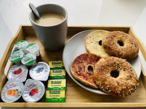 a tray with a plate of donuts and a cup of coffee at The Idyllic City Centre Apartment & Free Parking in Sheffield