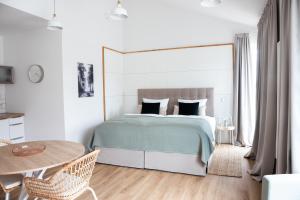 - une chambre blanche avec un lit et une table dans l'établissement Moderne neue Apartments zum Wohlfühlen im Boardinghouse bed & butter, à Hasbergen