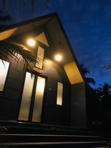 a house with lights on the side of it at night at Liverpool Estate - Chilaw in Chilaw