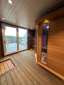 Habitación con terraza de madera y ventana grande. en Villa Arboretet - Seaside villa with private pool & infrared sauna in the heart of Arboretet, Bergen en Bergen