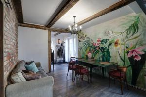 una sala de estar con una mesa y una pintura en la pared en Frica Ludvika Garden Apartment, en Liepāja