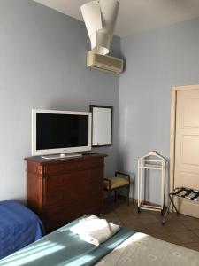 a bedroom with a tv on top of a dresser at Numero 3 in Cagliari