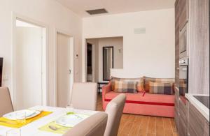a living room with a table and a red couch at Vera Project Apartment in Milan