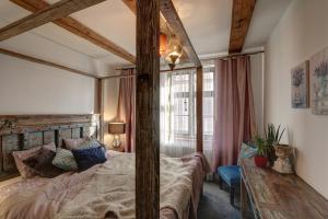 1 dormitorio con 1 cama grande con marco de madera en Frica Ludvika Garden Apartment, en Liepāja