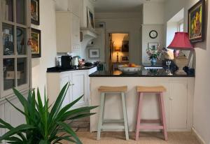 a kitchen with two pink stools at a counter at Fabulous Grade 2 Listed Home in Heart of Stow in Stow on the Wold