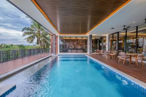 an indoor pool with tables and chairs on a balcony at ValStar Hotel Canggu in Canggu