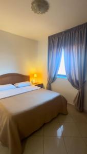 Schlafzimmer mit einem Bett und einem Fenster mit blauen Vorhängen in der Unterkunft Hotel Futuro in Aversa